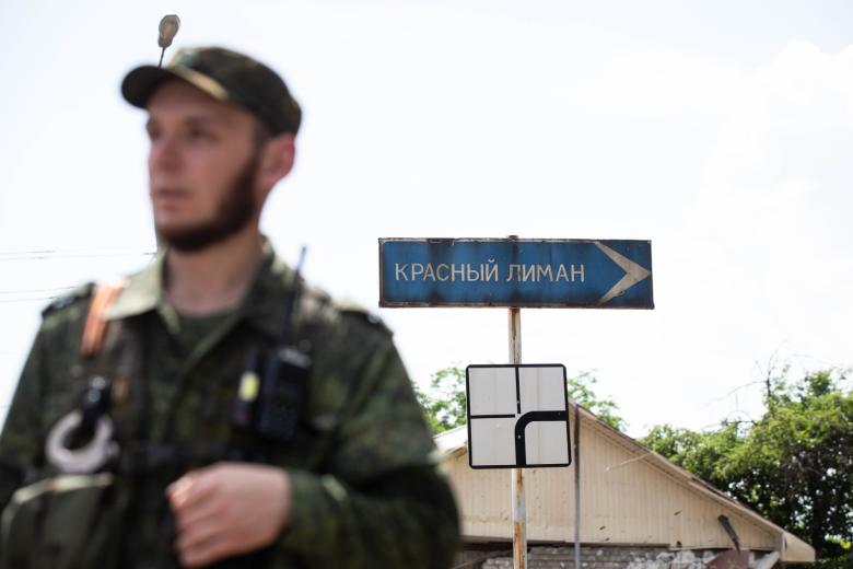 Военнослужащий Народной милиции ЛНР у знака на Красный Лиман