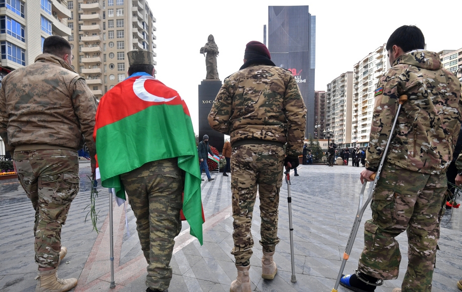 Люди несут портреты к памятнику жертвам Ходжалы «Ана Харайи» в Баку