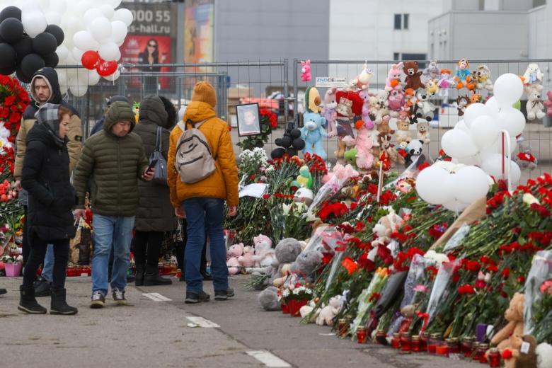 Люди у стихийного мемориала в память о погибших при теракте у здания концертного зала «Крокус Сити Холл»