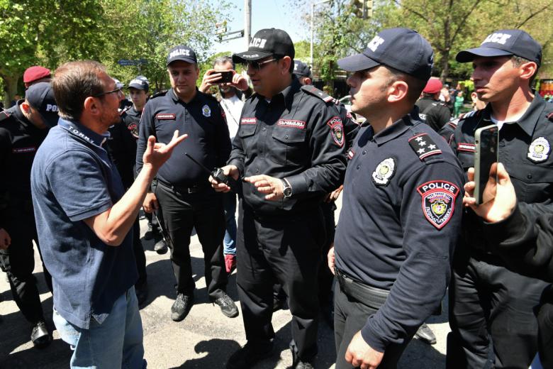 Сотрудники правоохранительных органов общаются с участником акции протеста в Ереване