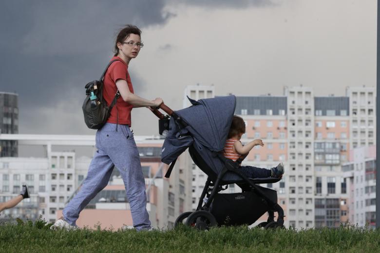 Женщина с ребенком в коляске гуляет на природе в Москве