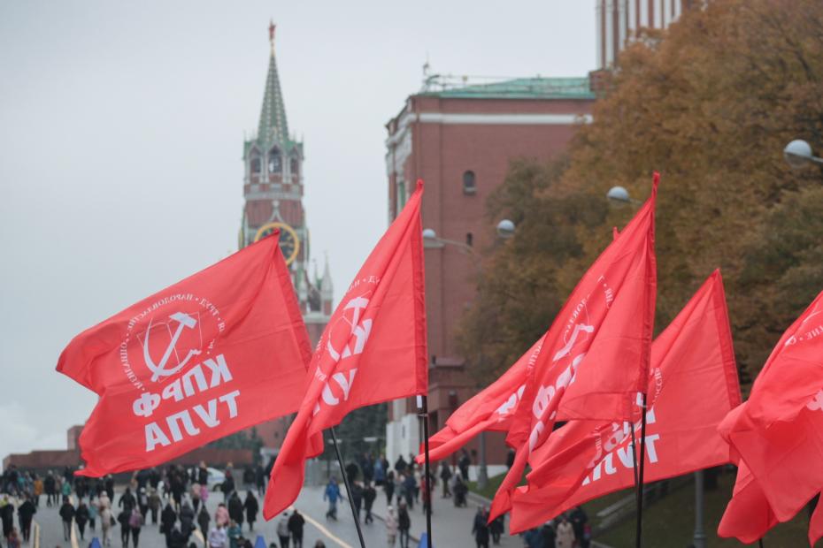 Красные флаги в руках людей во время митинга в честь 105-й годовщины Великой Октябрьской революции на Манежной площади