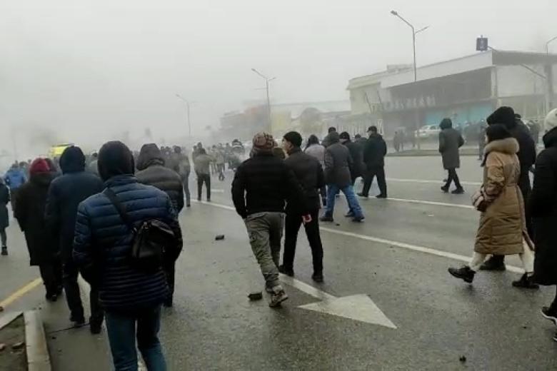 Люди на задымлённой улице в Алма-Ате