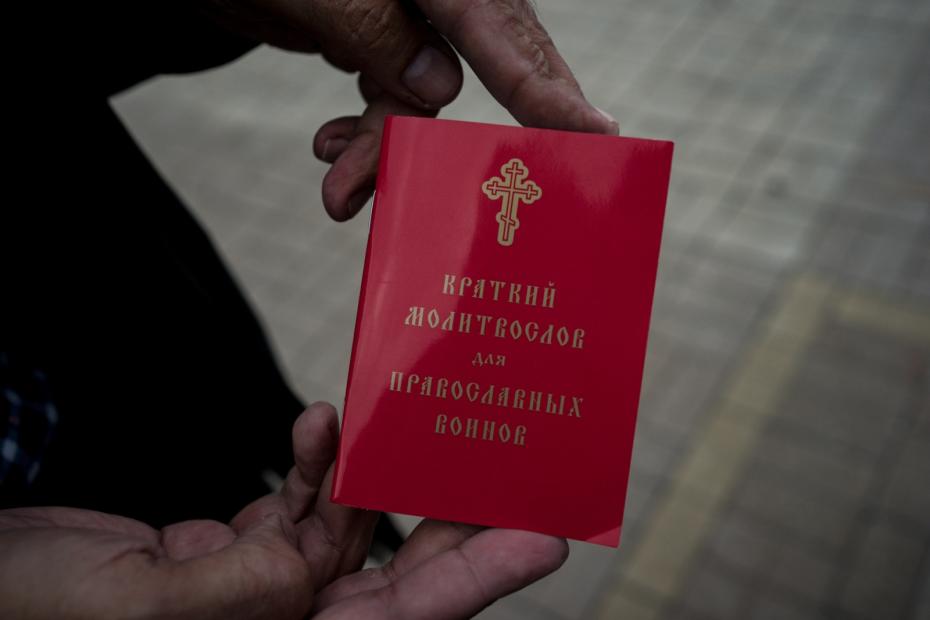 Мужчина показывает свою книжку молитвенник