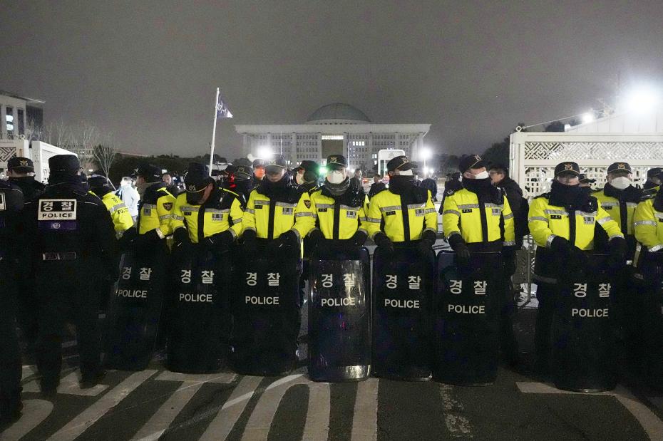 Протестующие против введения военного положения и полицейские возле здания Национальной ассамблеи, Сеул, Южная Корея
