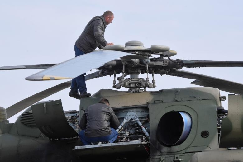 Техники осматривают вертолет Ми-8 