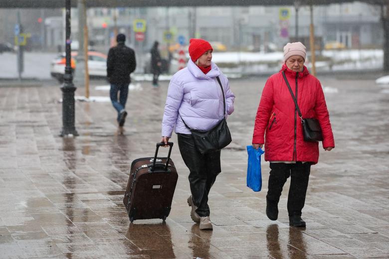 Люди во время весеннего снегопада в Москве