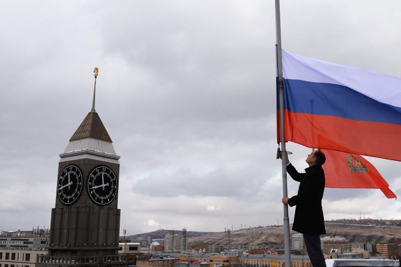 Приспущенные государственные флаги России и Красноярского края на крыше здания городской администрации Красноярска в знак траура по погибшим при прорыве дамбы на реке Сейба