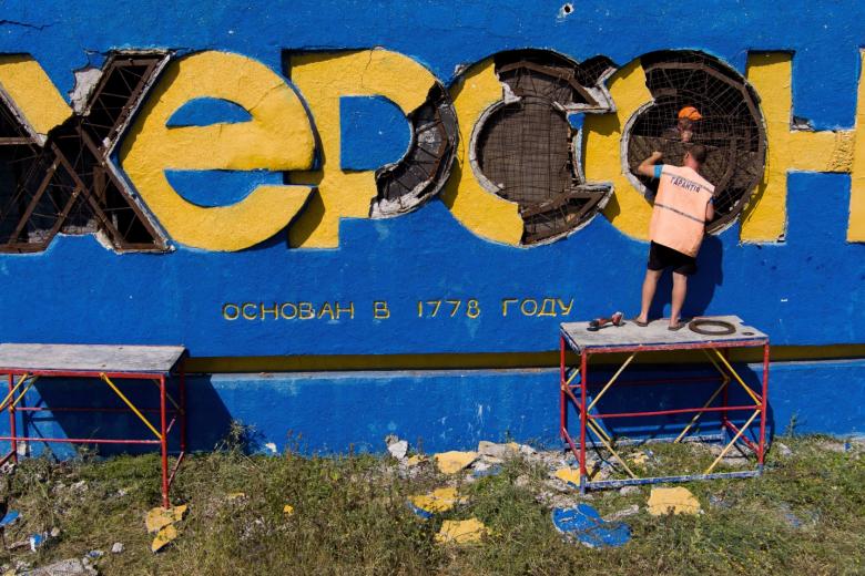Мужчины во время восстановления надписи «Херсон» на въезде в город