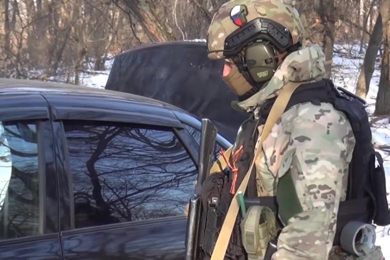Сотрудник ФСБ РФ у автомобиля боевиков