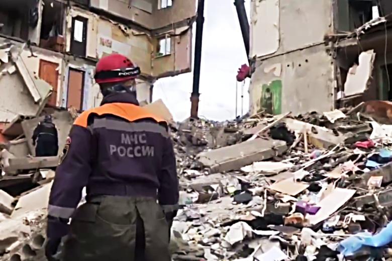 Сотрудник МЧС с собакой ищут людей под завалами на месте взрыва газа в жилом пятиэтажном доме на улице Сибирской в Нижнем Тагиле