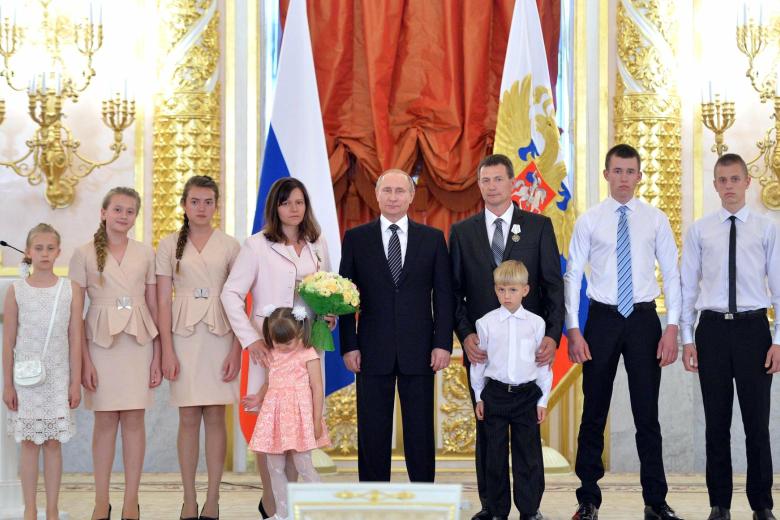 Президент России Владимир Путин (в центре) и семья Поливановых из Республики Крым на церемонии награждения орденами «Родительская слава» многодетных родителей