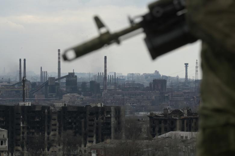 Боец специального отряда быстрого реагирования на крыше здания в Мариуполе. На дальнем плане – металлургический комбинат «Азовсталь»