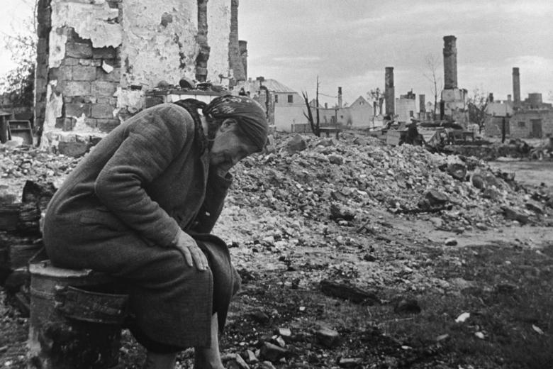 Местная жительница на пепелище своего разрушенного дома после боев Великой Отечественной войны