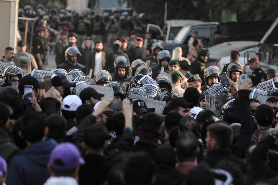 23 January 2023, Iraq, Baghdad: People confront security forces during a demonstration in front of the Swedish embassy after the burning of the Quran in Sweden by a right-wing politician named Rasmus Paludan