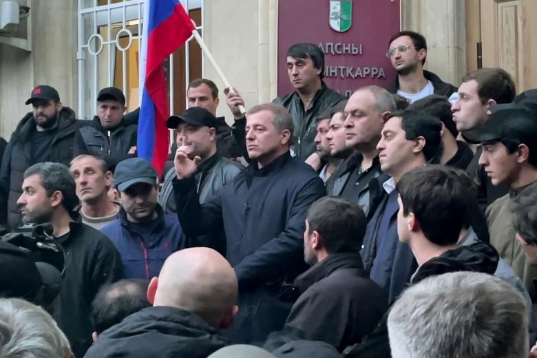 Руководитель оппозиционной организации «Абхазское народное движение» Адгур Ардзинба (в центре) у входа в здание парламента Абхазии в Сухуме.