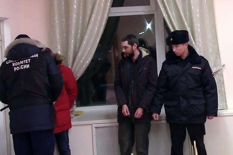 Задержанный 36-летний местный житель (второй справа), подозреваемый в убийстве ребёнка в детском саду "Сказка", во время следственных действий