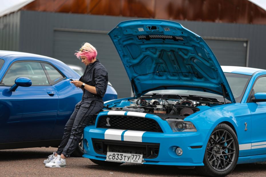 Участники гонки серьезных и мощных автомобилей по прямой на открытом воздухе