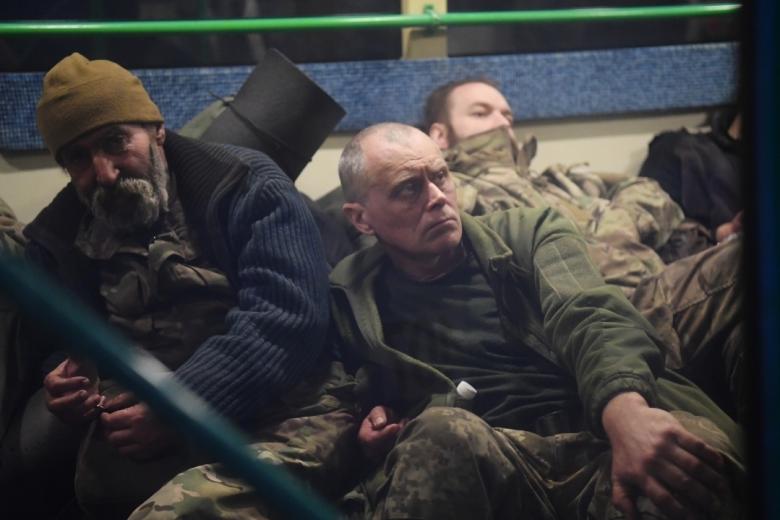 Сдавшиеся в плен украинские военнослужащие и боевики националистического батальона «Азов» сидят в автобусе у следственного изолятора в Еленовке