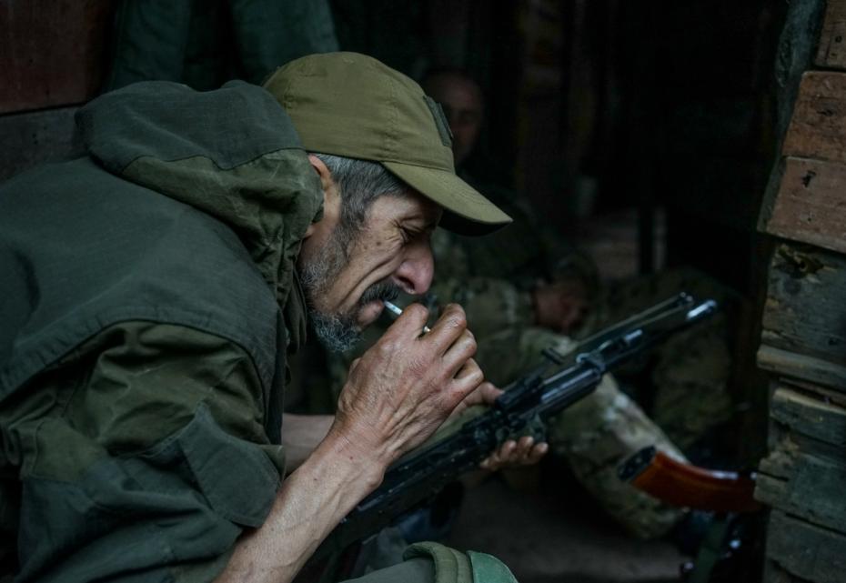 Солдат чистит затвор автомата пока на позициях тихо
