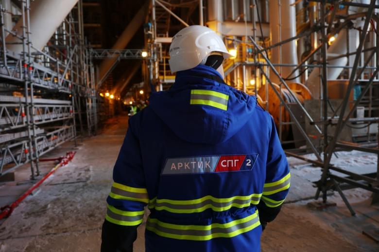 Работник на территории, где идет строительство плавучего завода для сжиженного газа