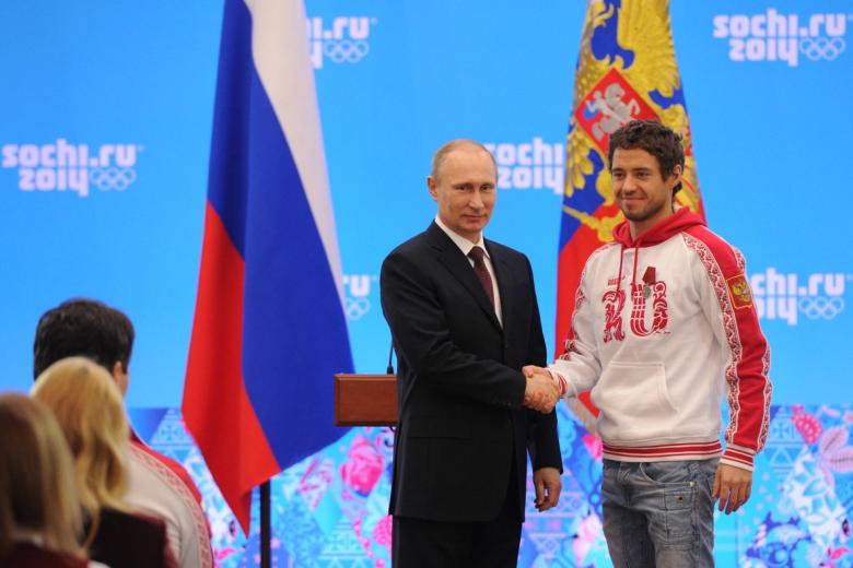 24 февраля 2014 года. Президент России Владимир Путин (слева) и бронзовый призёр Олимпийских игр в лыжных гонках Илья Черноусов во время церемонии награждения российских призёров XXII зимних Олимпийских игр в Сочи