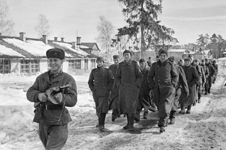 Боец РККА конвоирует колонну немецких солдат, плененных под Москвой,