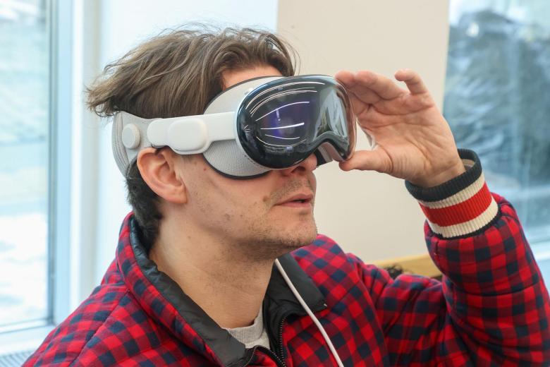 Мужчина в шлеме виртуальной реальности Apple Vision Pro