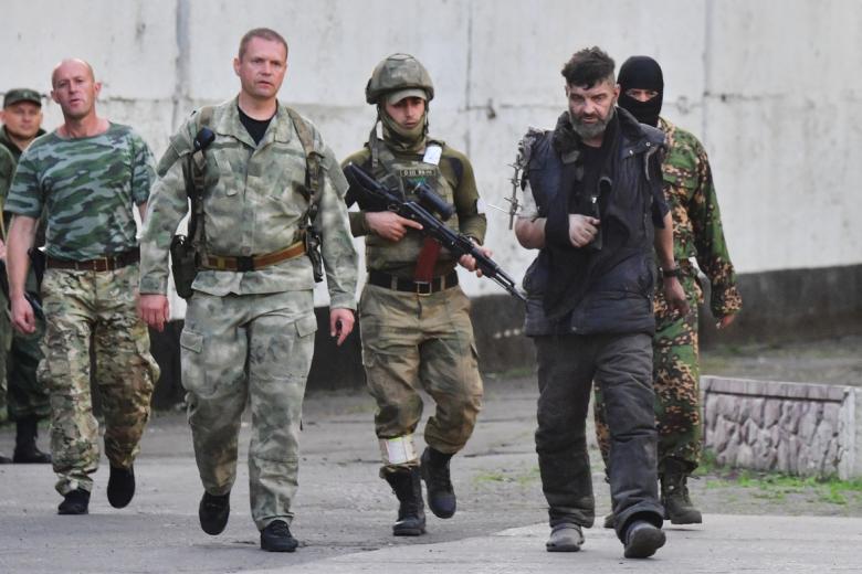 Военные сопровождают сдавшегося в плен украинского военнослужащего с «Азовстали»
