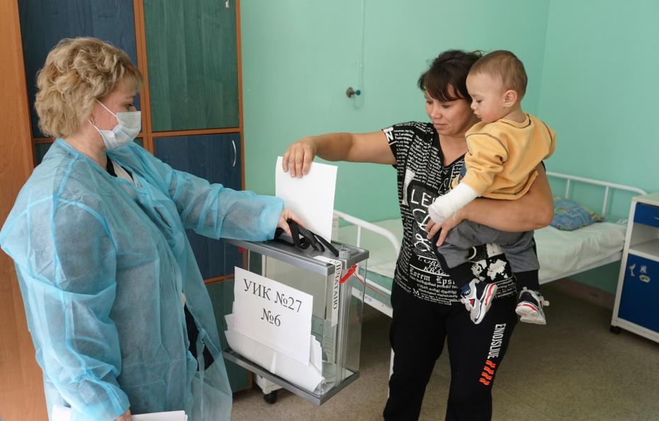 Пациентка голосует в палате со своим ребенком