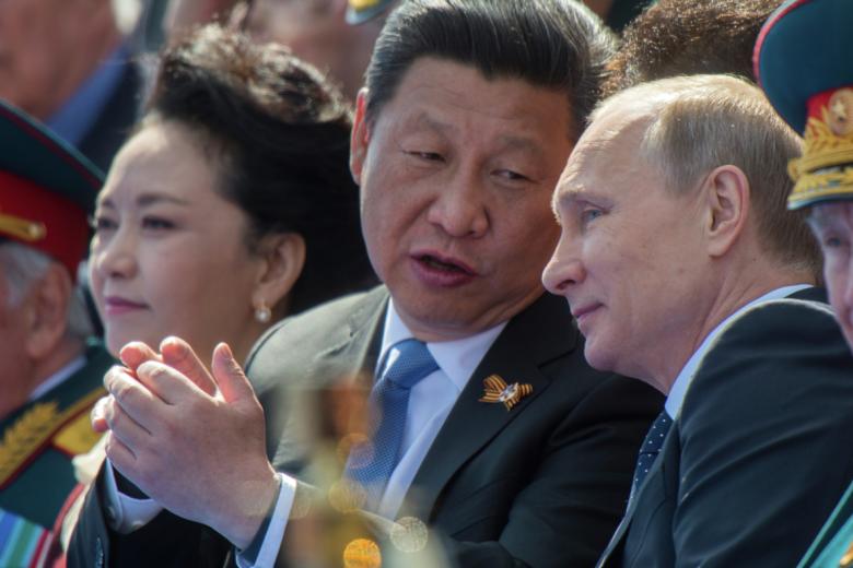 Владимир Путин (справа) и председатель Китайской Народной Республики Си Цзиньпин с супругой Пэн Лиюань во время военного парада в ознаменование 70-летия победы в Великой Отечественной войне. 2015 год