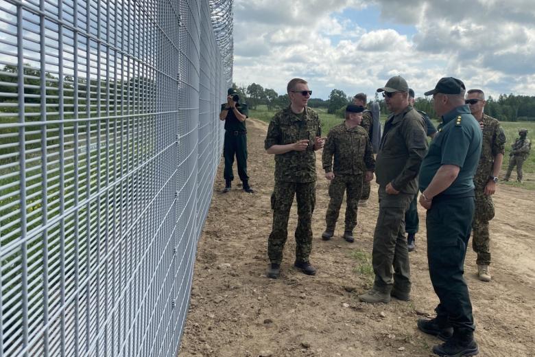 Президент Латвии Эдгарс Ринкевичс (слева) беседует с пограничниками у пограничного заграждения на границе Латвии с Россией