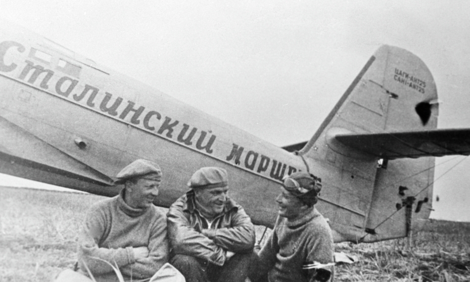 Лётчики Валерий Чкалов (в центре), Георгий Байдуков (слева) и Александр Беляков сидят около самолёта после приземления на острове Удд (впоследствии остров Чкалова) в Охотском море