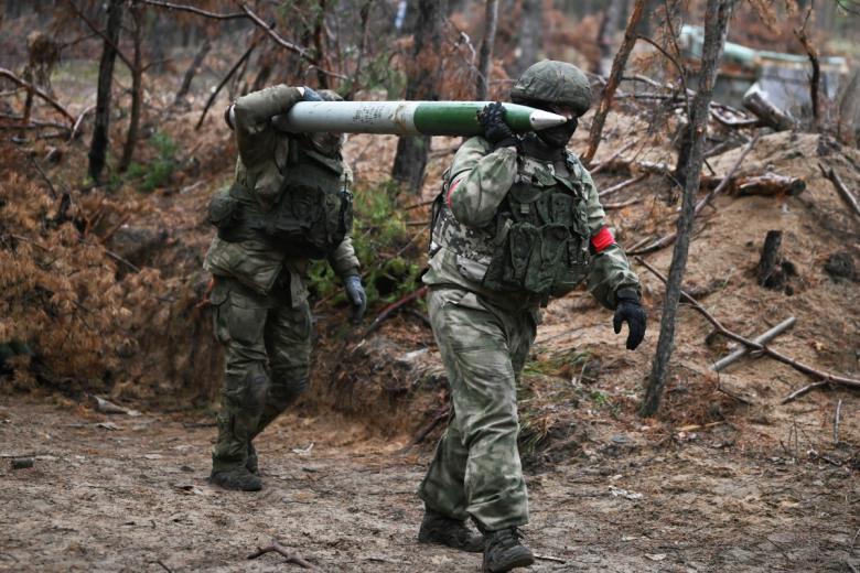 Военнослужащие гвардейского мотострелкового полка ЦВО переносят снаряд для РСЗО БМ-21 «Град»