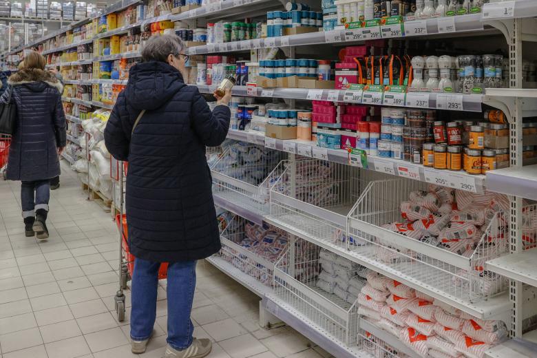 Покупатель выбирает приправы в гипермаркете