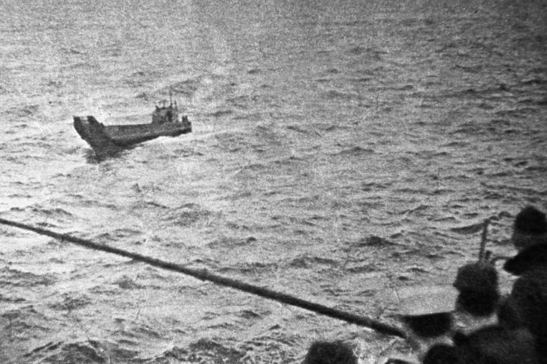 Американские моряки авианосца «Кирсардж» смотрят на баржу, на которой с 17 января по 7 марта 1960 года дрейфовали советские военнослужащие