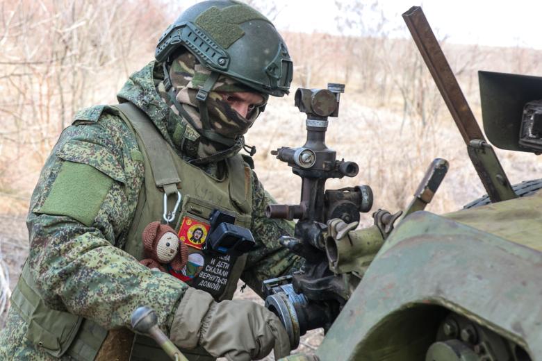 Военнослужащий 1155-го мотострелкового полка во время работы расчета 122-мм гаубицы Д-30