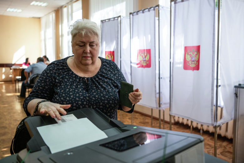 Женщина голосует на избирательном участке в Курске